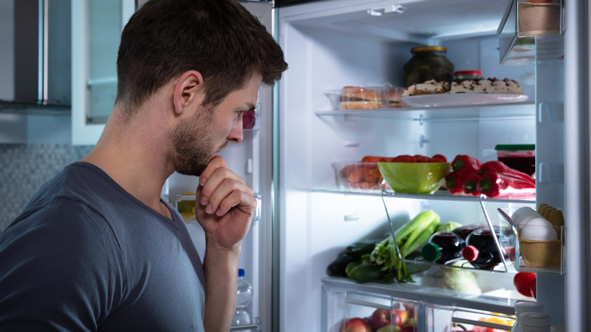 A man looks in the fridge.